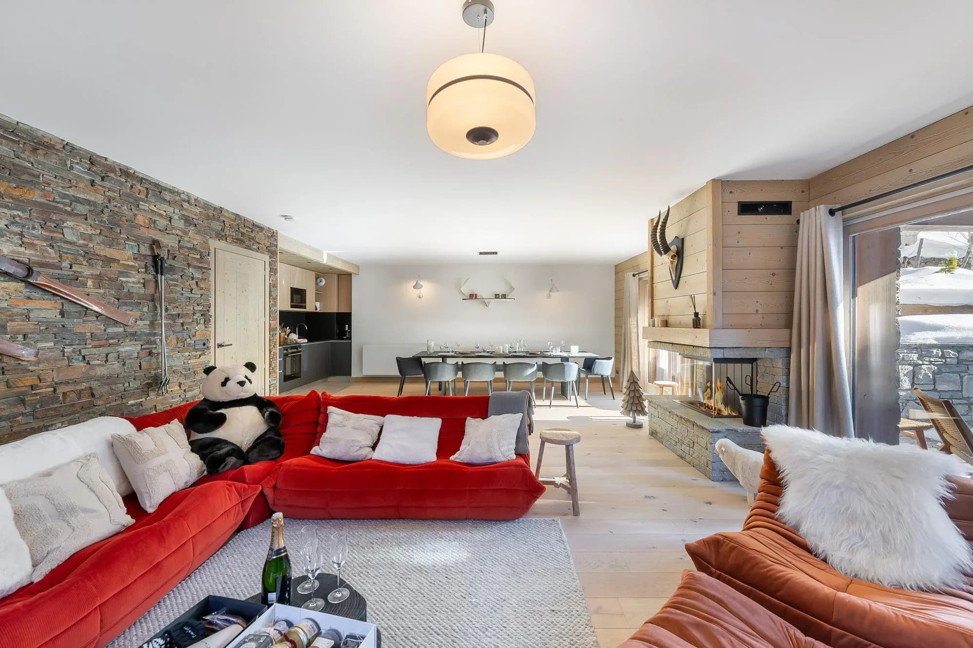 Living room with red corner sofa, corner fireplace and stone feature wall