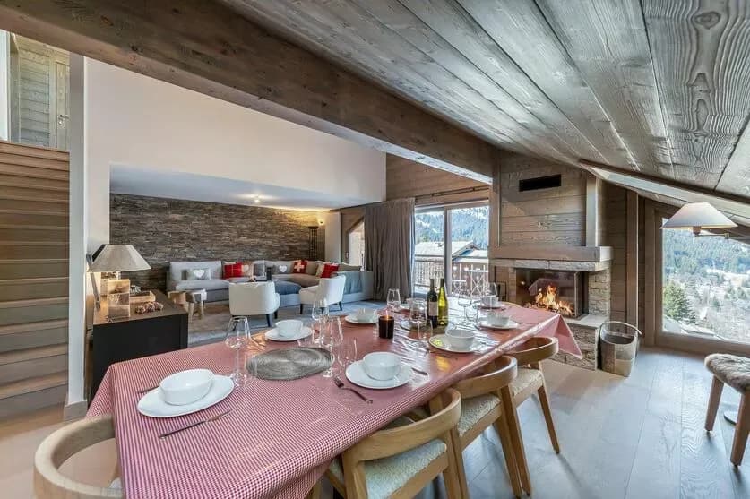 Dining table beside the open kitchen and wood fireplace