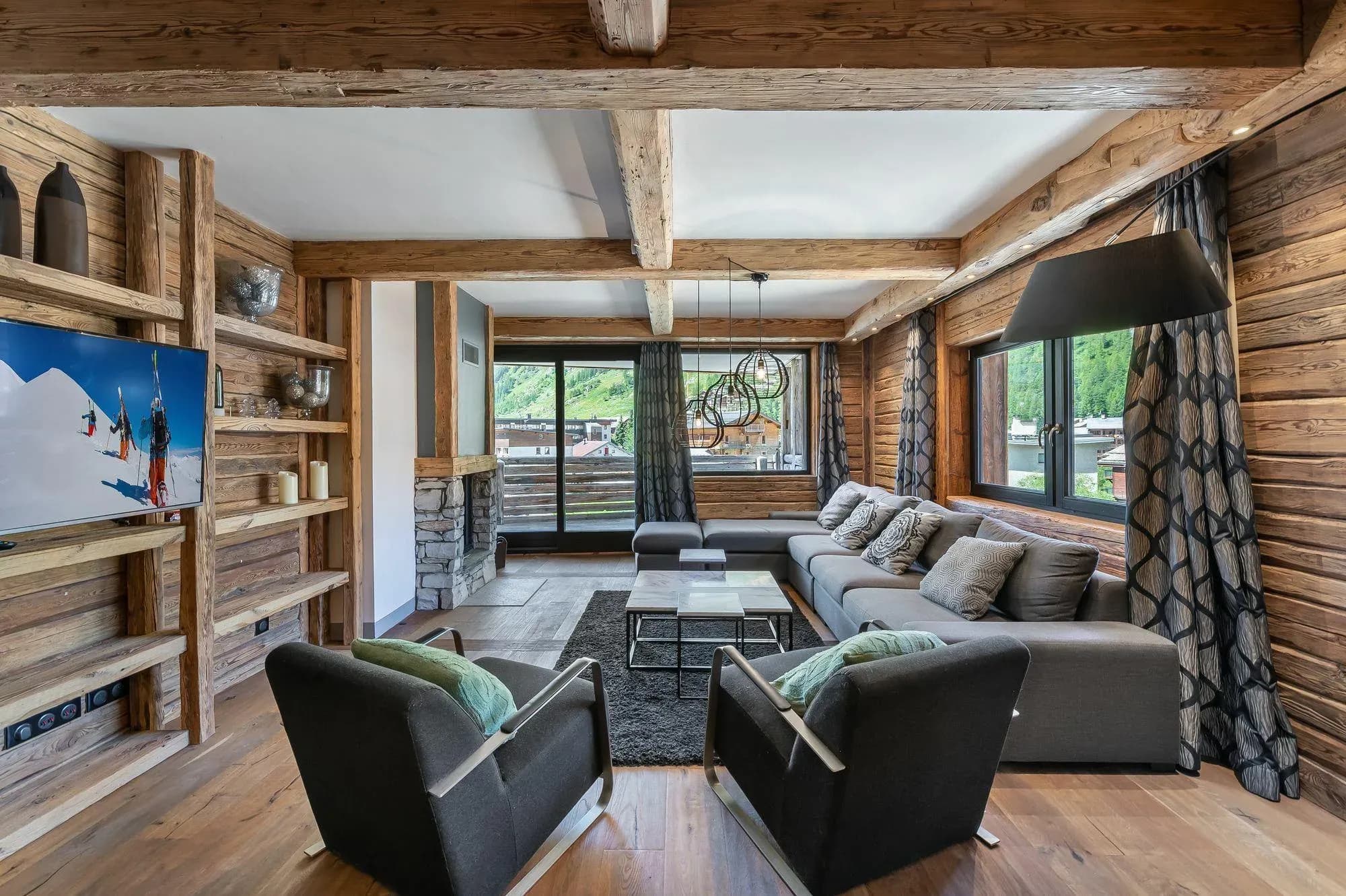 Living room with grey corner sofa, two armchairs and stone fireplace