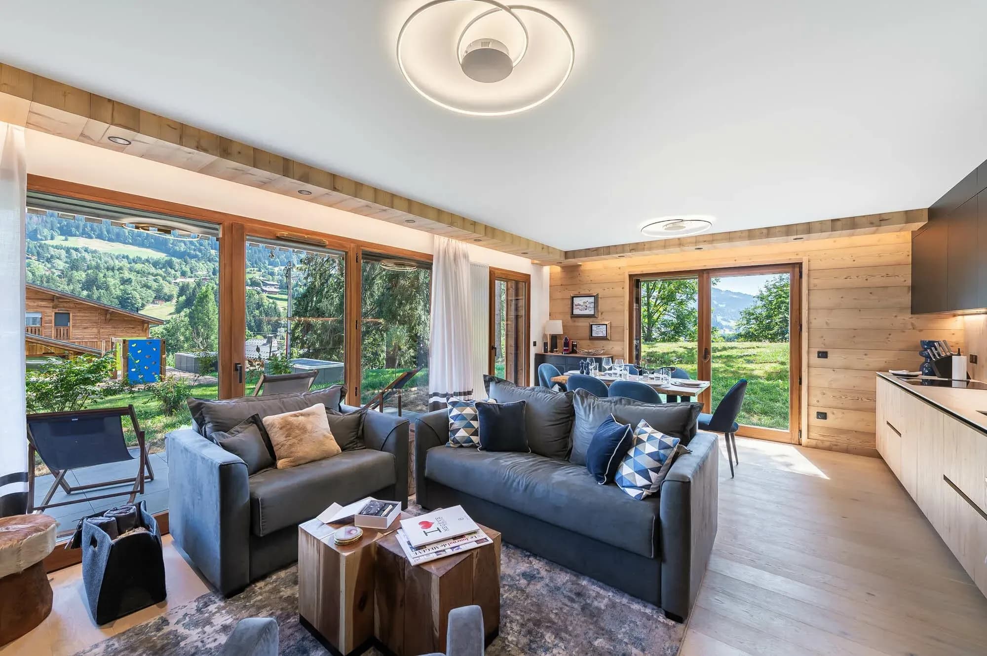 Living room with two grey sofas and glass doors opening to the terrace and valley view