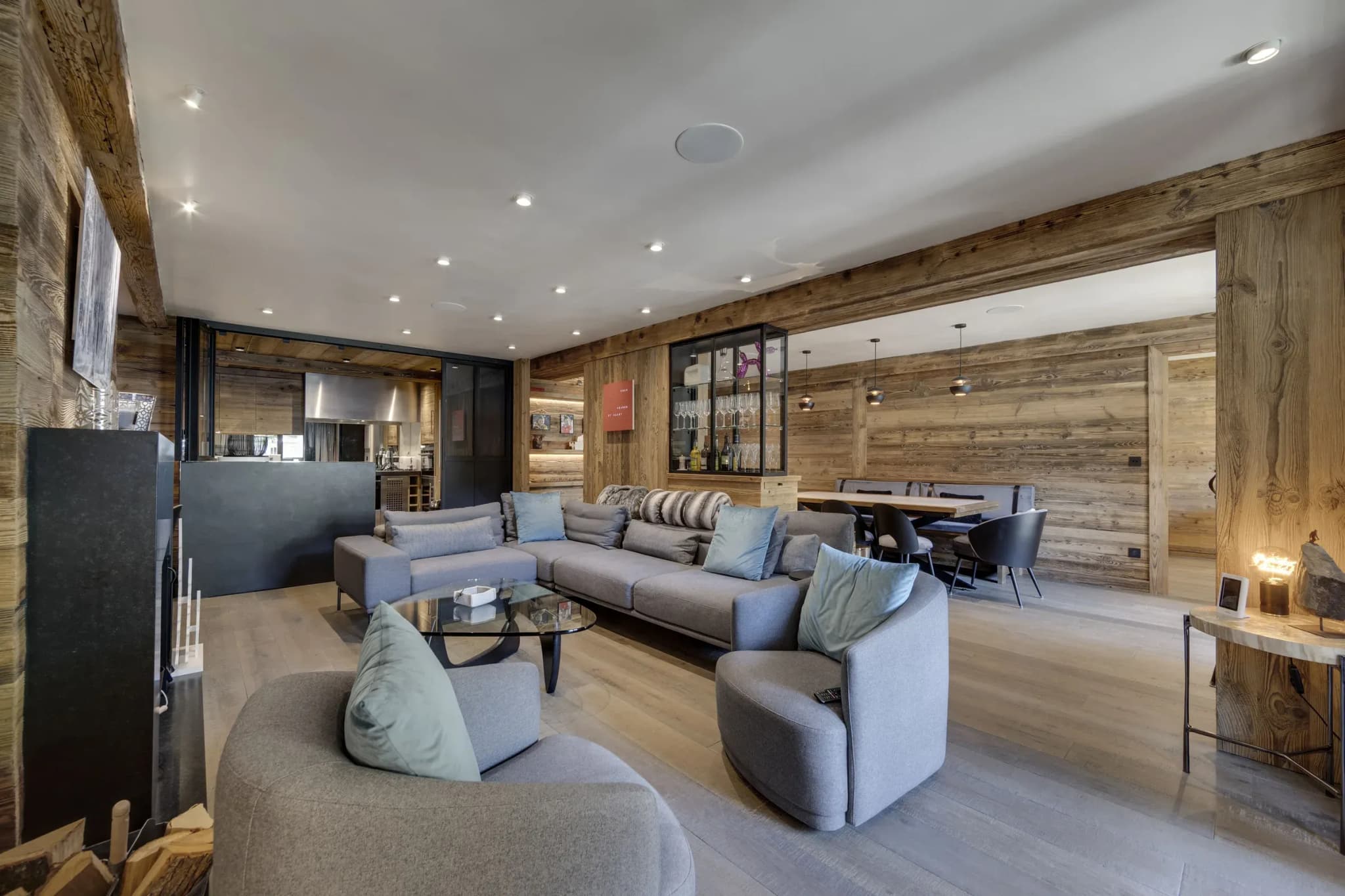 Living room with grey corner sofa, two armchairs and glass coffee table