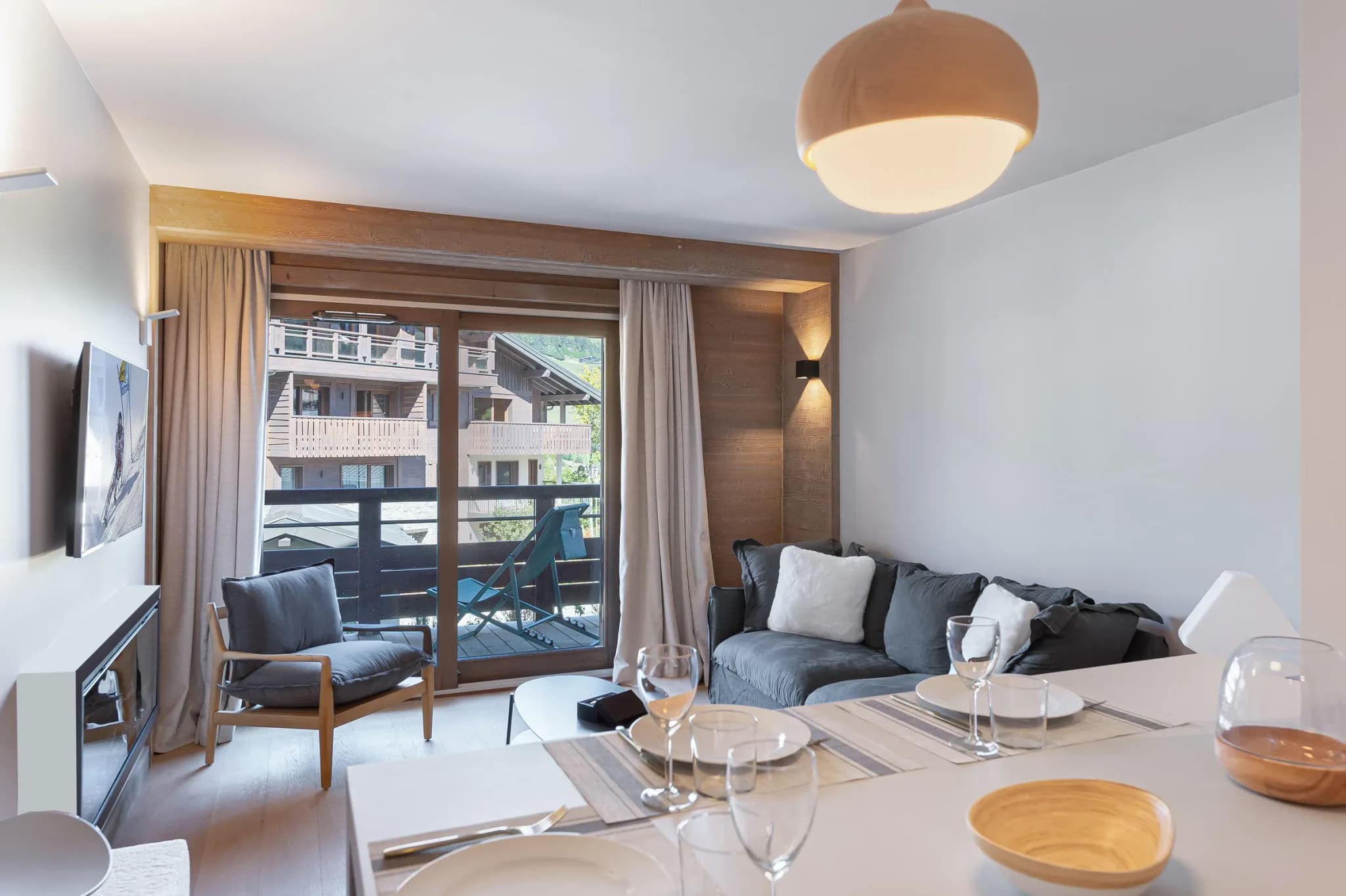 Living area with grey sofa, armchair and balcony doors