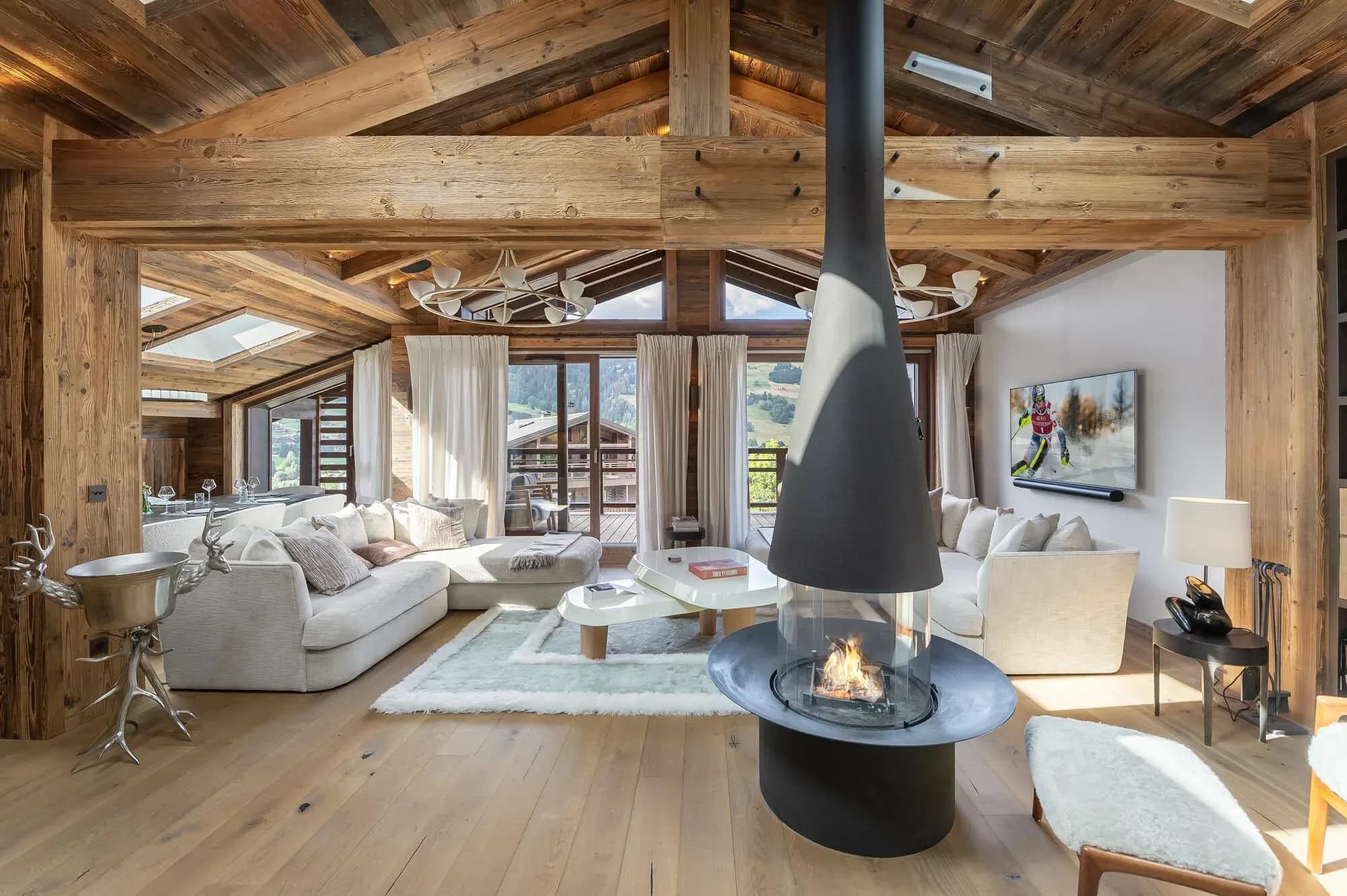 Living room with central hanging fireplace, two sofas and balcony doors