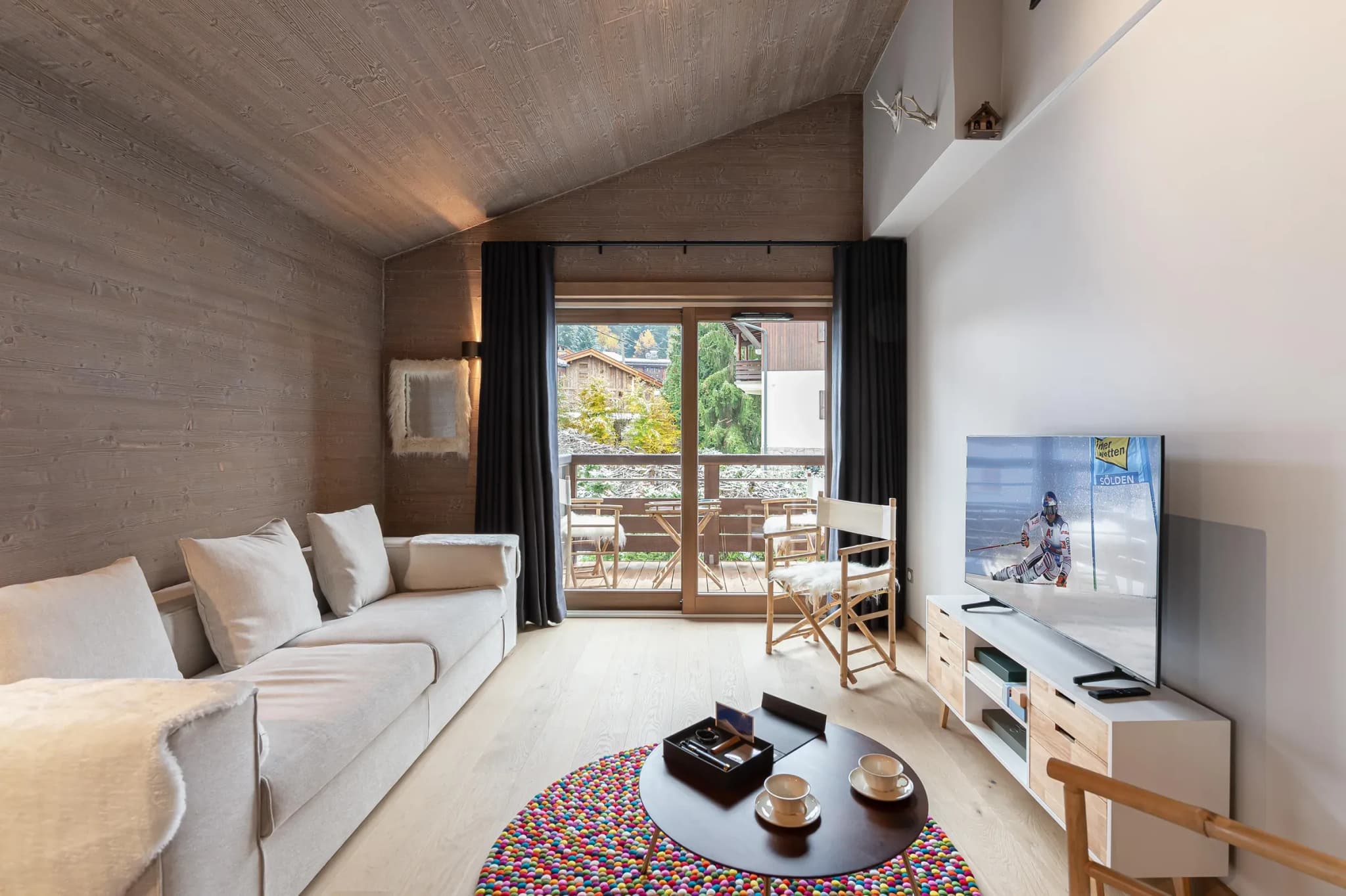 Living room with sofa, wall-mounted TV and balcony doors