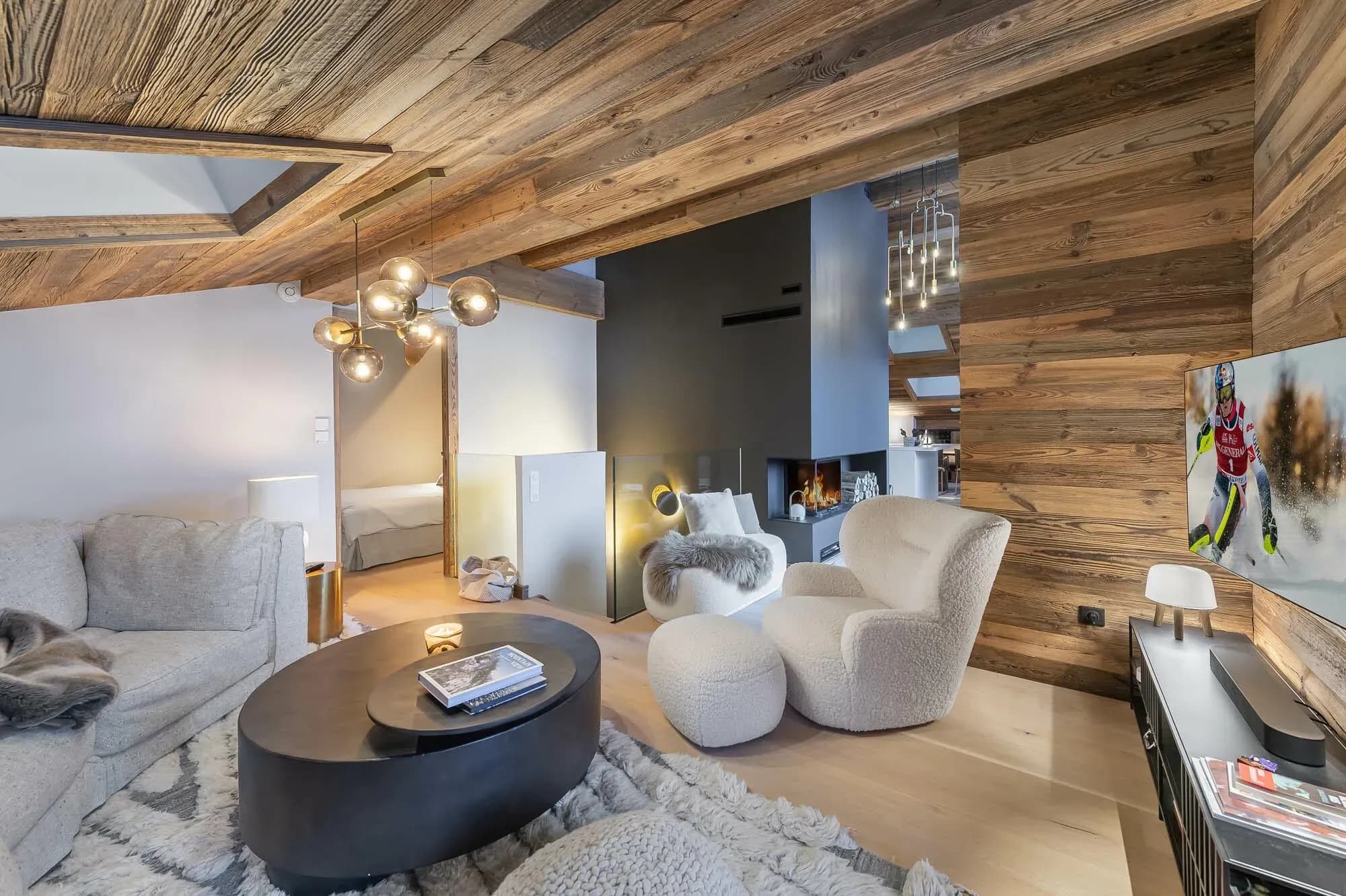 Lounge with grey sofa, two boucle armchairs and a corner fireplace