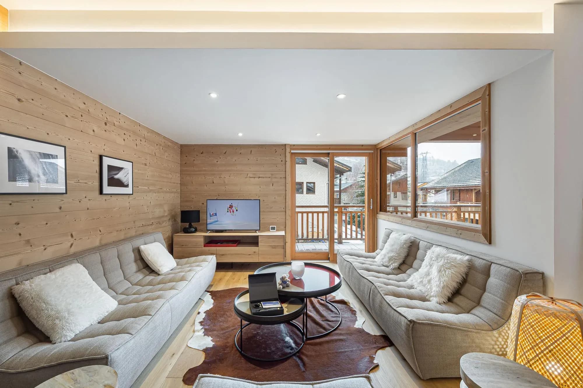 Living room with two grey sofas, cowhide rug and balcony door