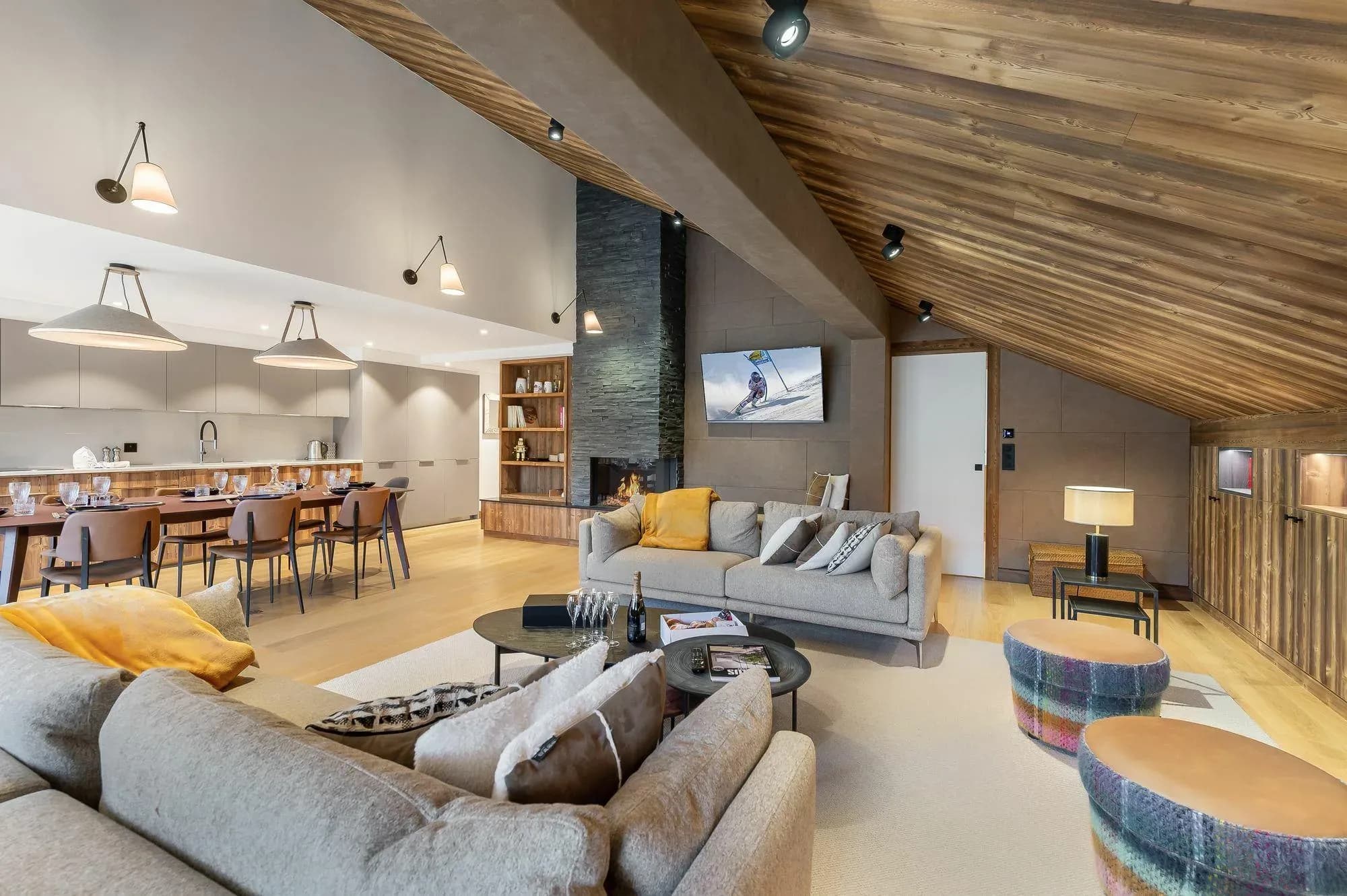 Open-plan living with vaulted wood ceiling, gas fireplace, and sectional seating for 8+