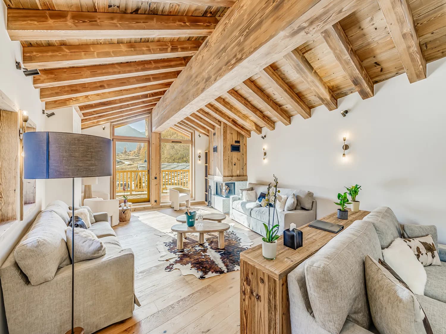 Open-plan lounge with fireplace and timber ceiling
