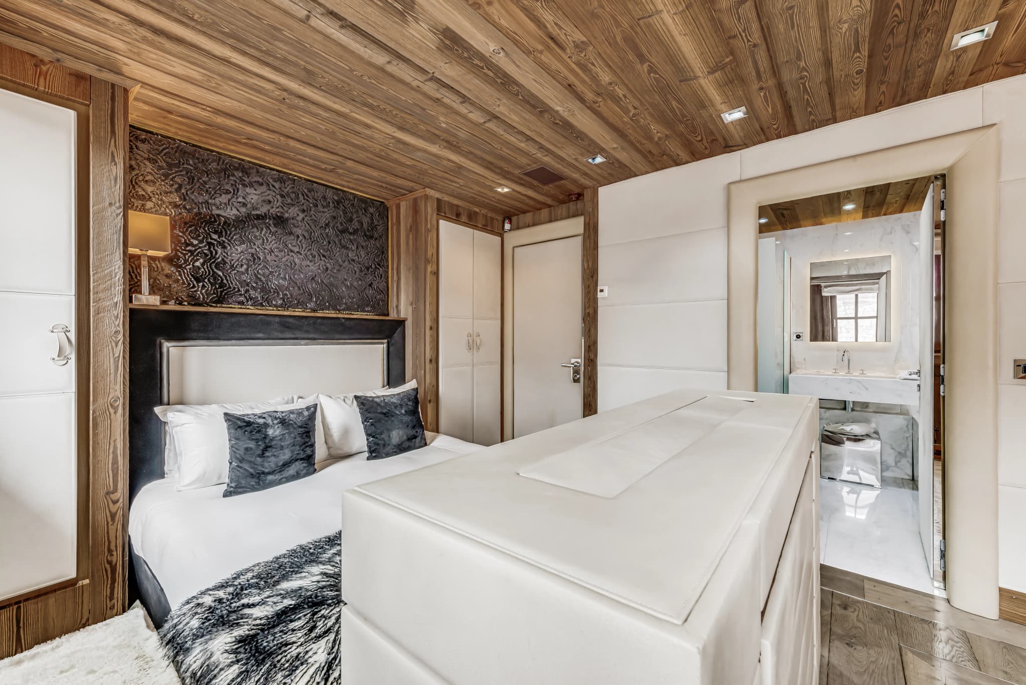 Double bedroom with a padded headboard and adjoining bathroom