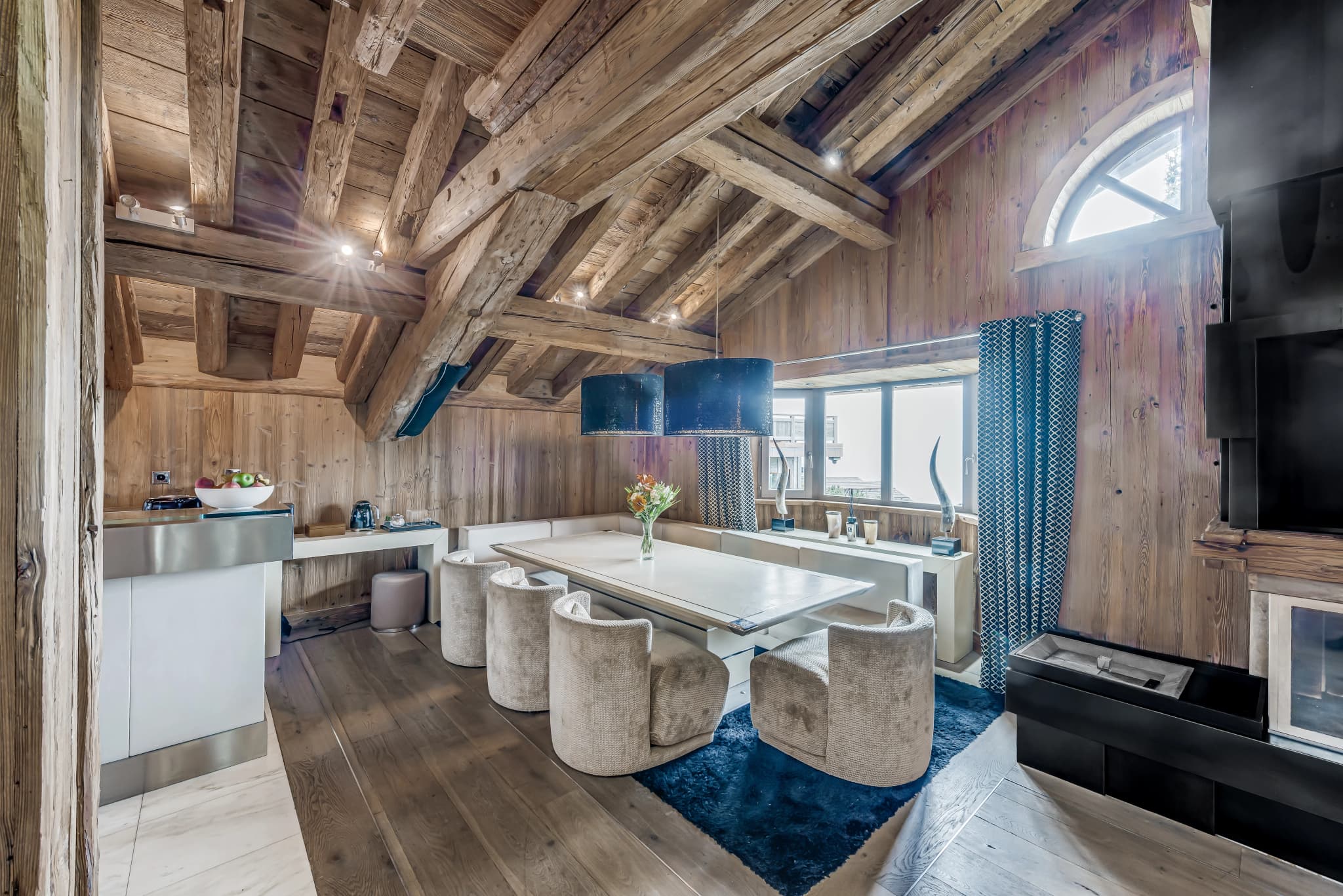 Dining nook with banquette seating beneath timber beams