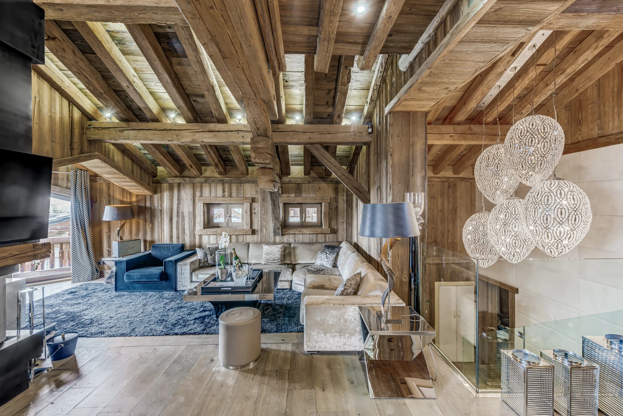 Vaulted living room with a central fireplace and exposed timber beams