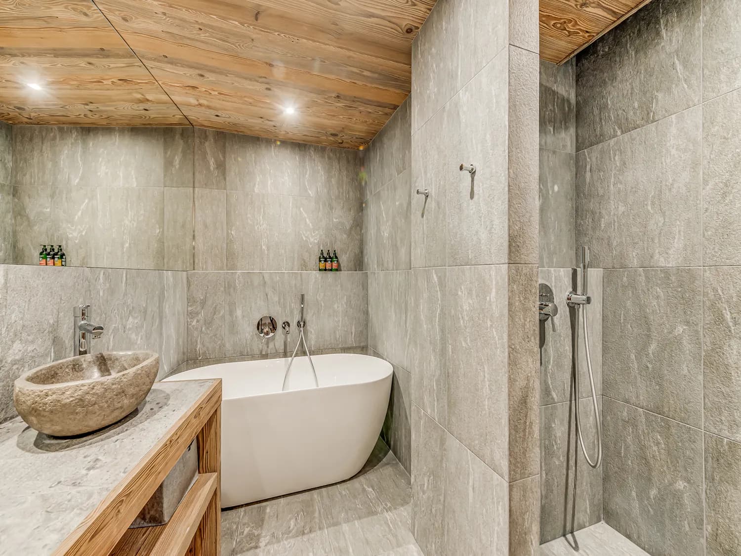 Stone bathroom with a freestanding bath and walk-in shower