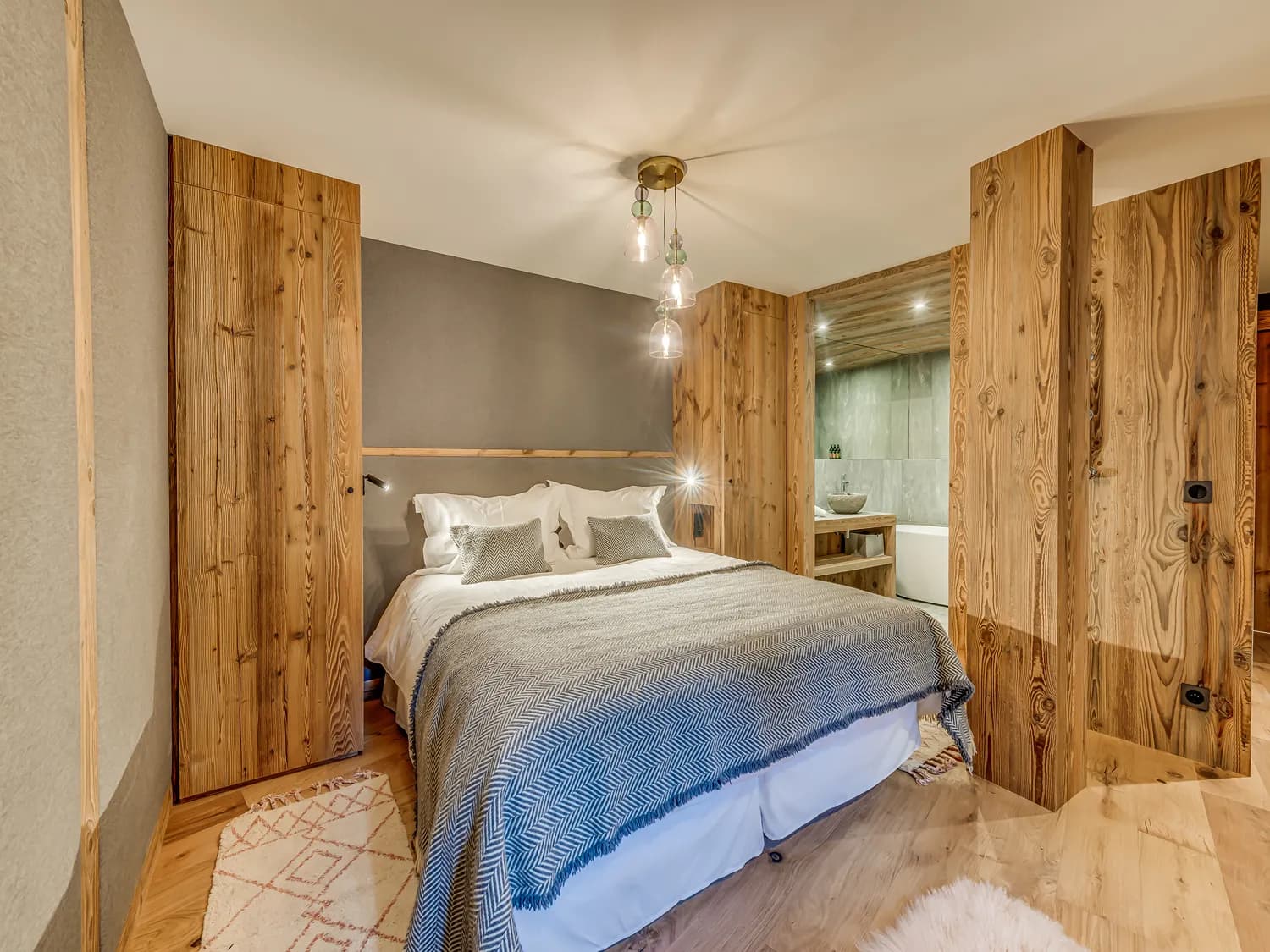Double bedroom with timber panelling and a padded headboard