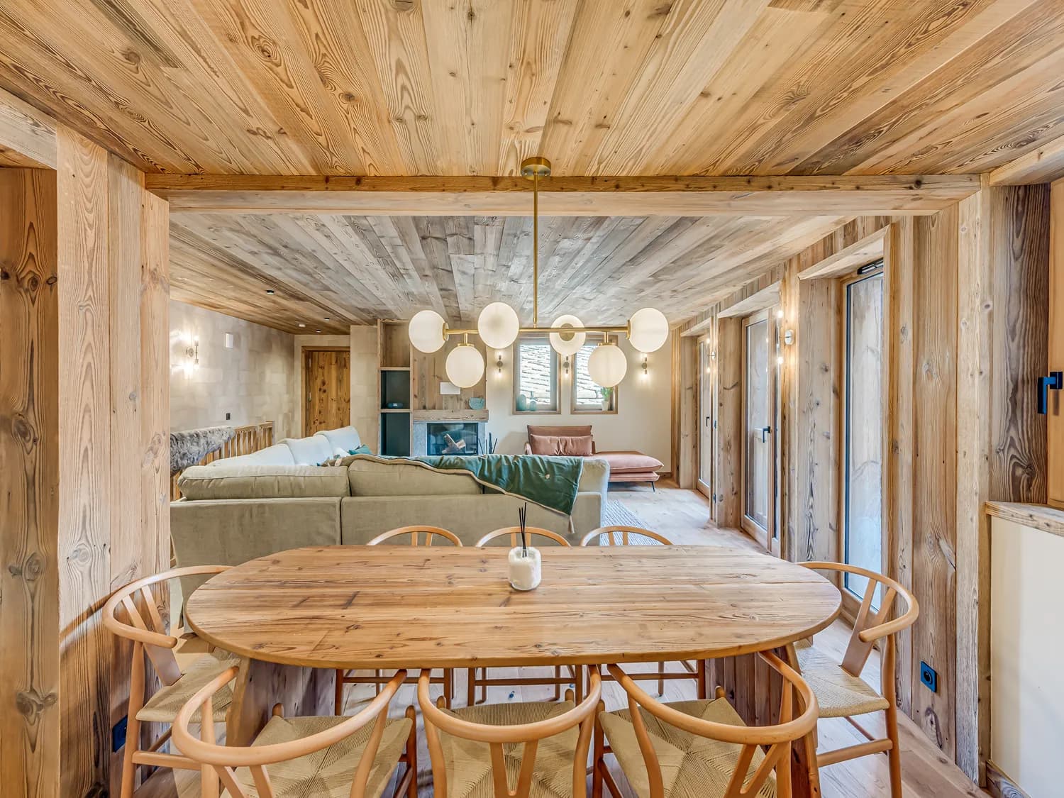 Dining table with the lounge and fireplace beyond