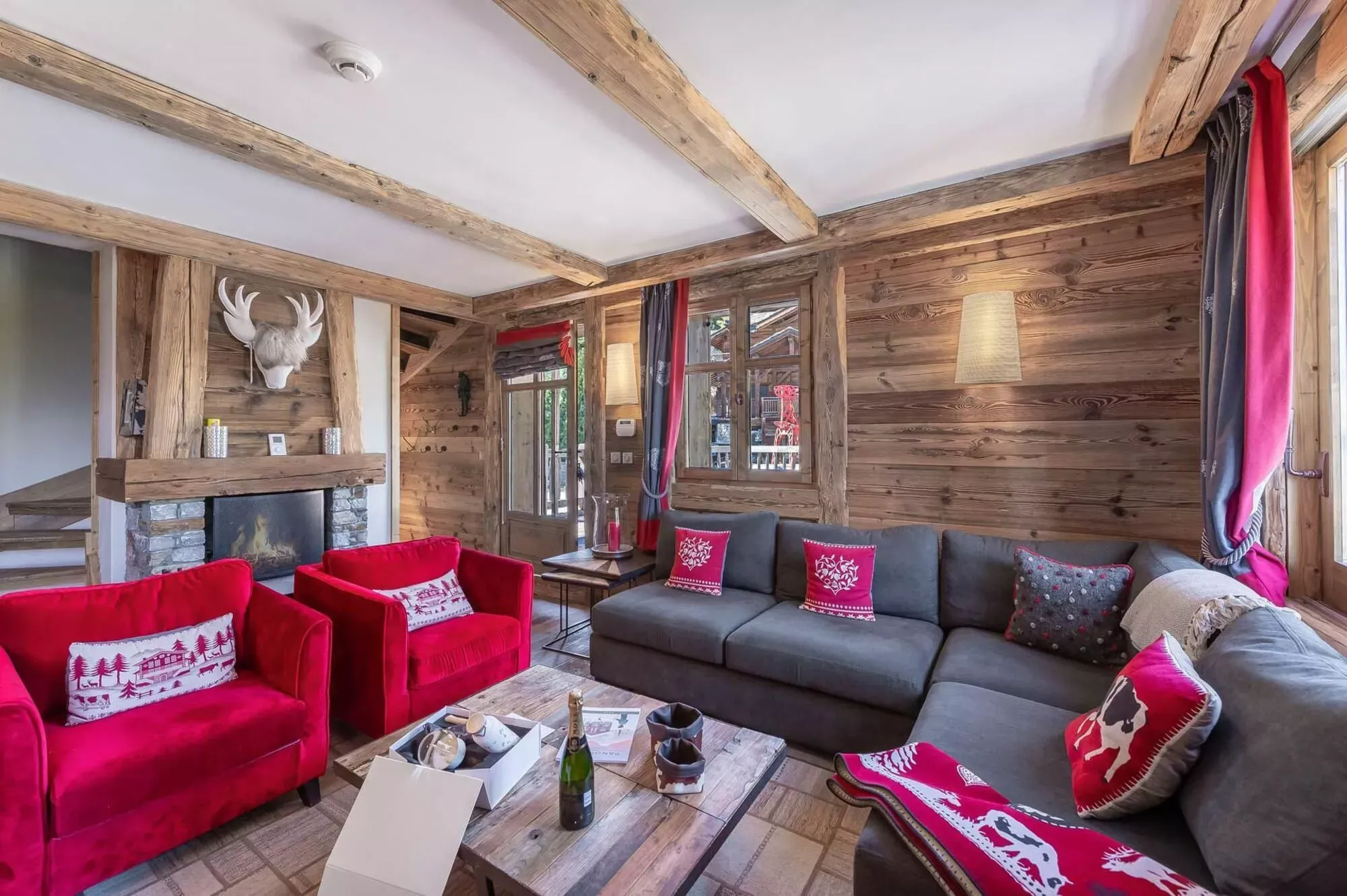 Wood-panelled living room with stone fireplace and terrace door