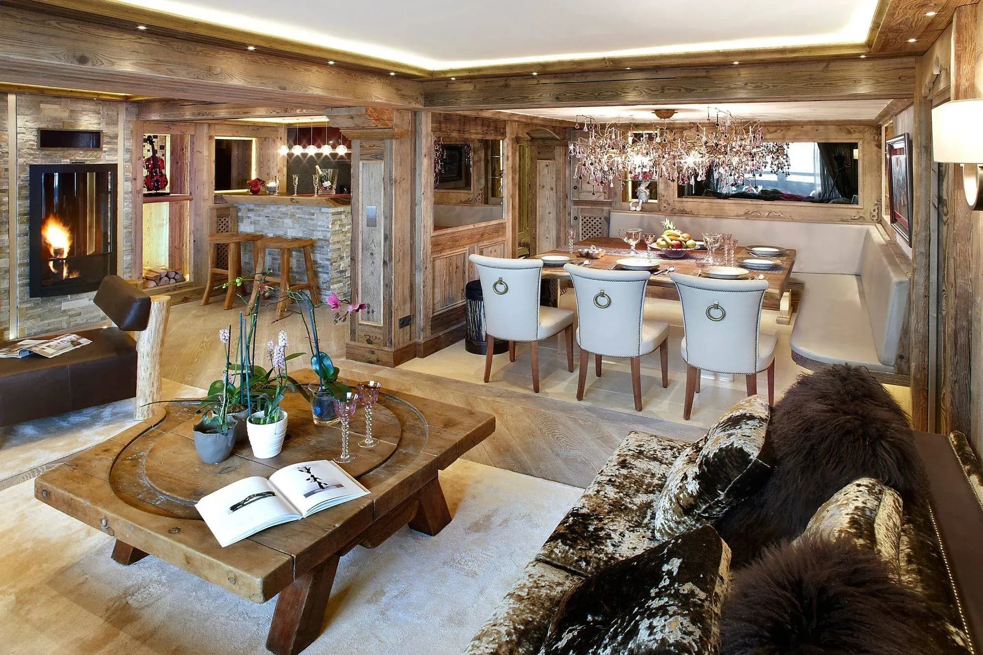 Open-plan lounge with stone fireplace, sofa and dining table with six seats