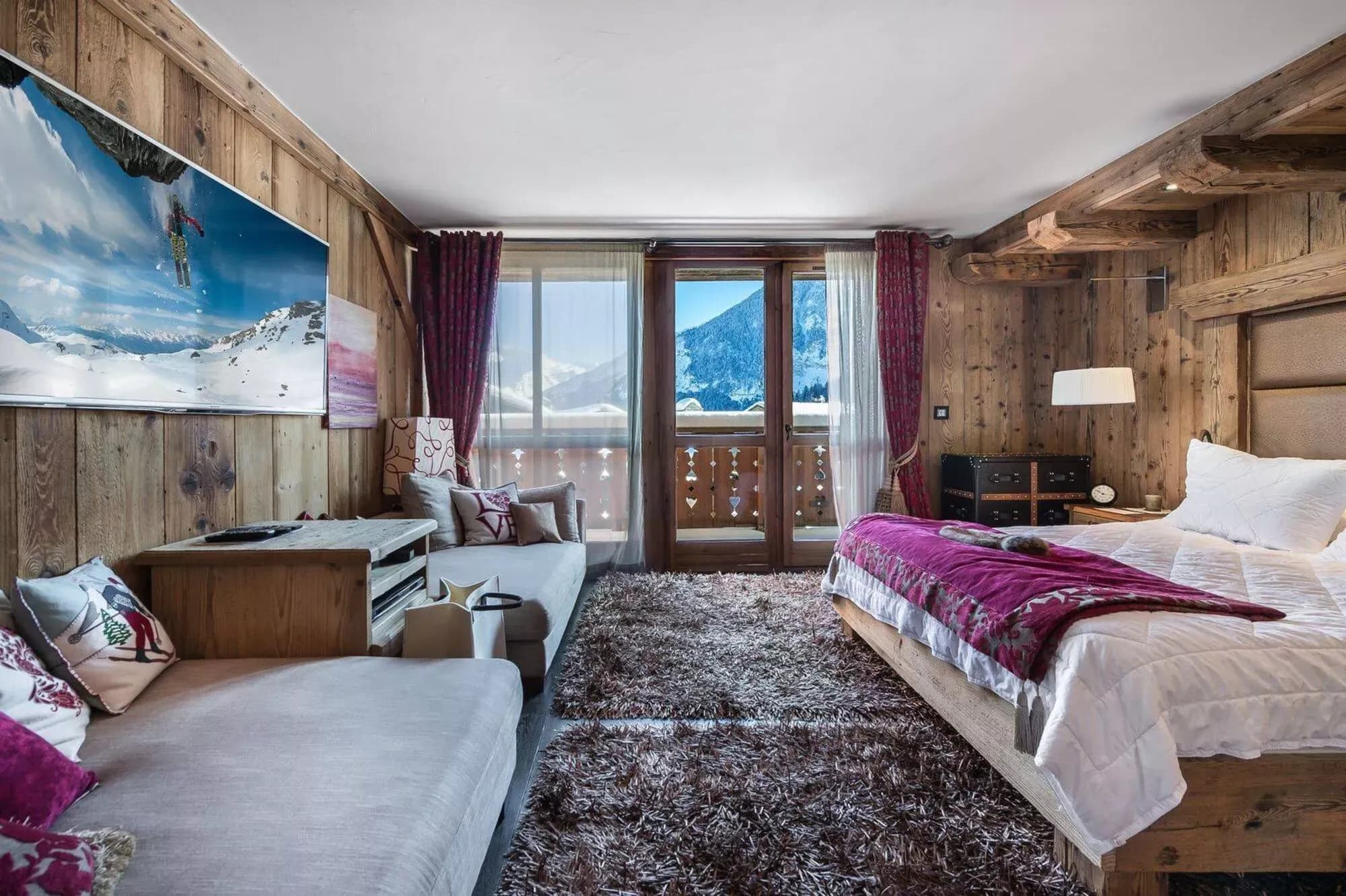 Double bedroom with a television and wide mountain-facing windows