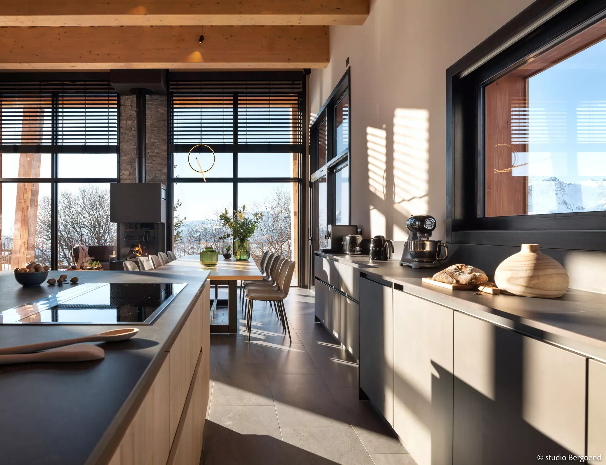 Open-plan kitchen and dining area with a gas fireplace and mountain views