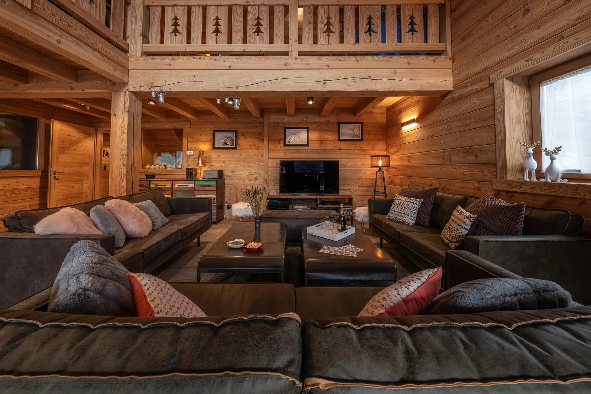 Living room with two large sofas, coffee tables, TV and mezzanine above