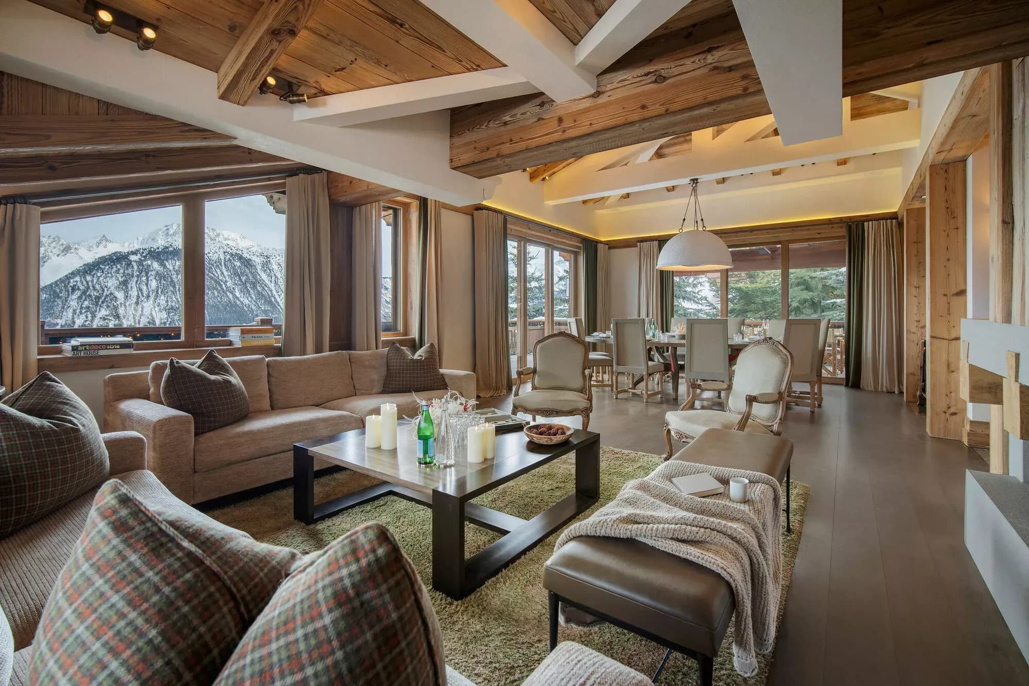 Living room with timber beams, lounge seating and panoramic windows
