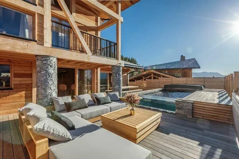 Terrace with corner sofa, low table and plunge pool beside the chalet