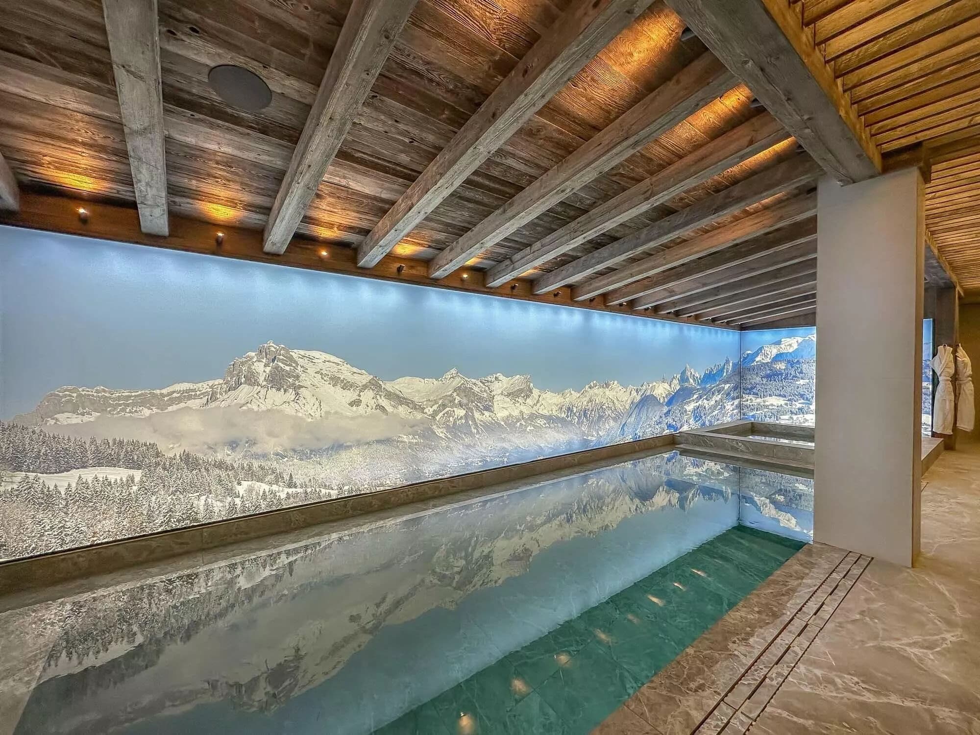 Indoor swimming pool with floor-to-ceiling mountain views