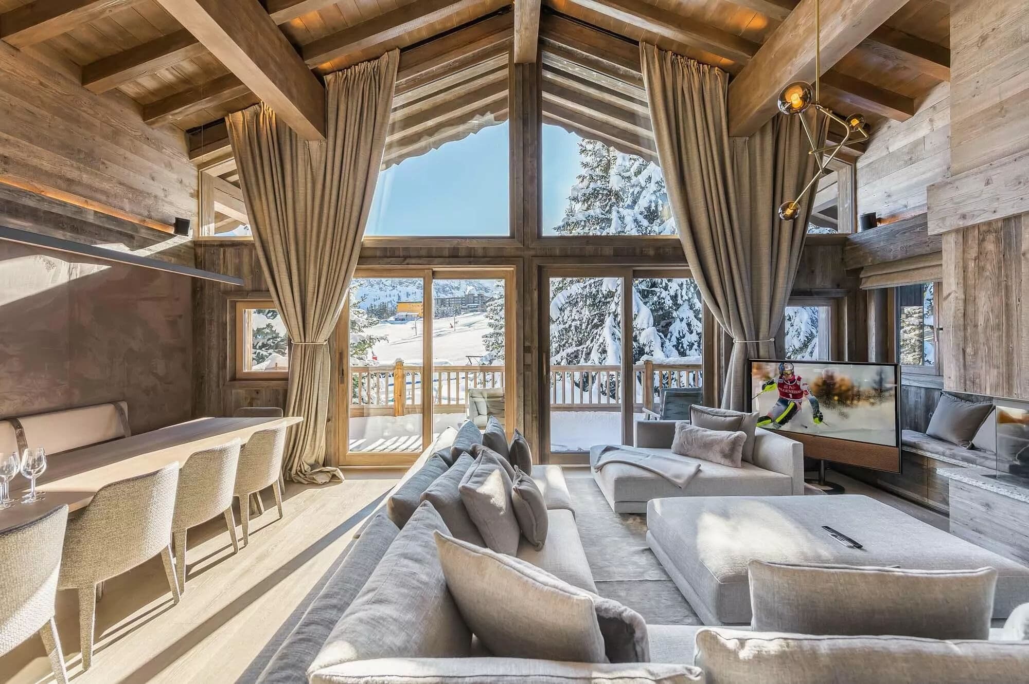 Living and dining area with large windows overlooking the slopes