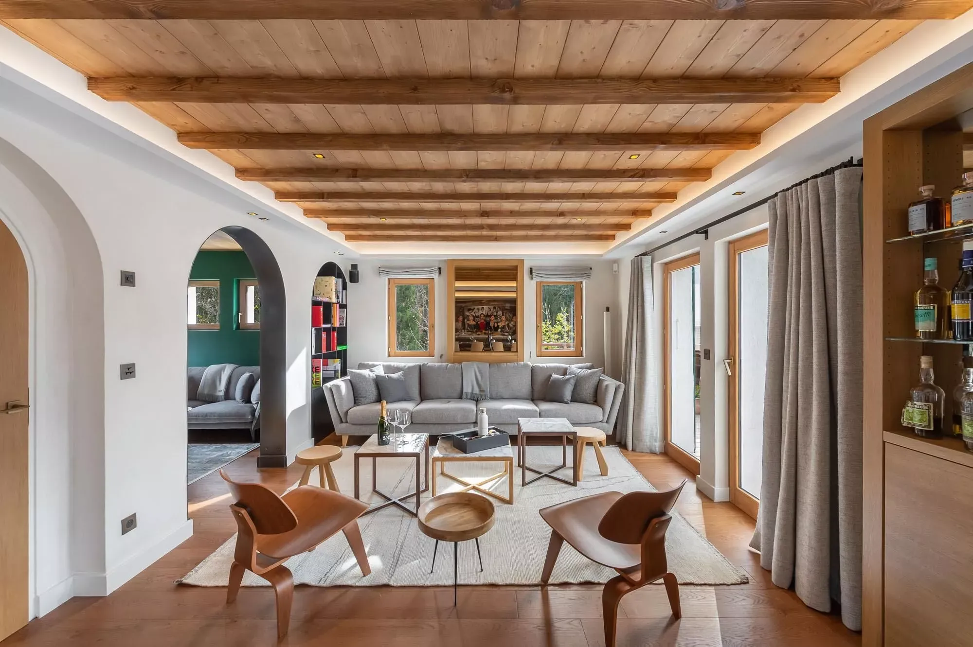 Open living area with timber ceiling, fireplace and balcony doors