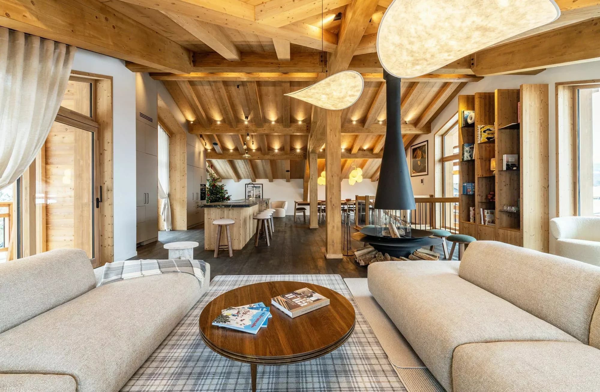 Top-floor living area with two lounges, central fireplace and dining space beyond
