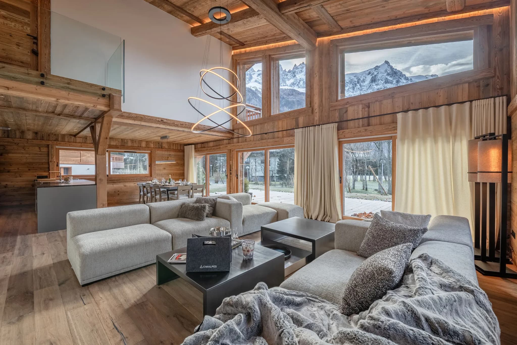 Living room with corner sofa, double-height windows and Mont Blanc view