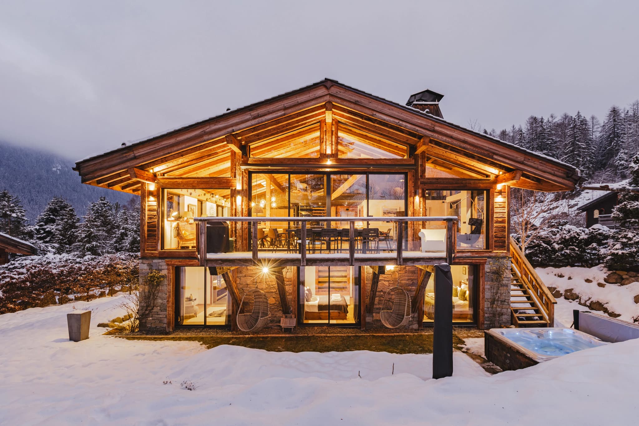 Illuminated timber chalet exterior surrounded by snow