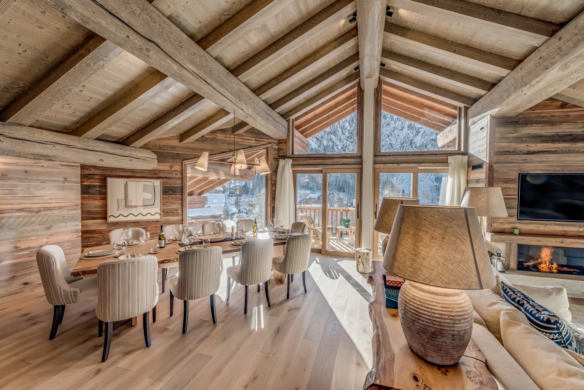Dining table beneath a vaulted ceiling beside the lounge