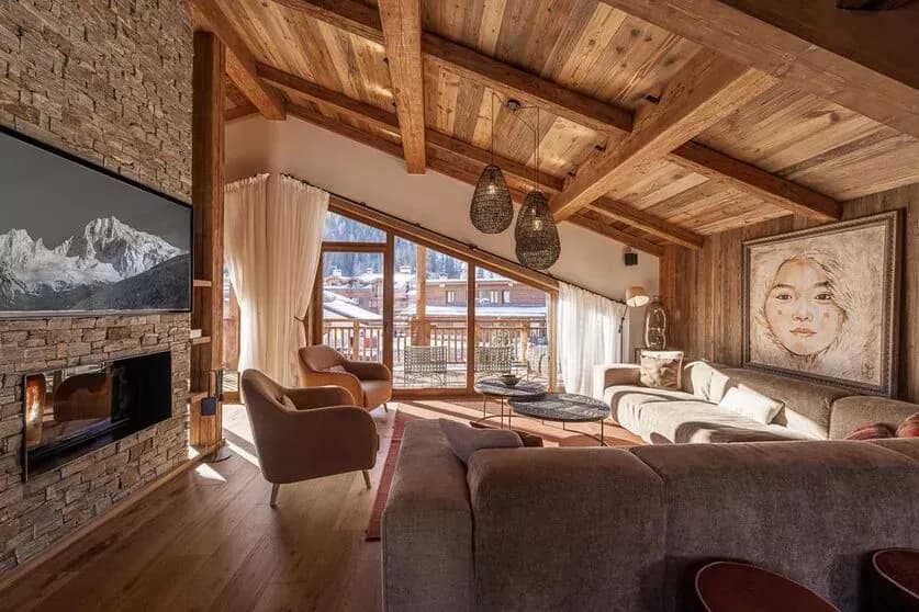 Top-floor living room with sofas, central fireplace and timber beams