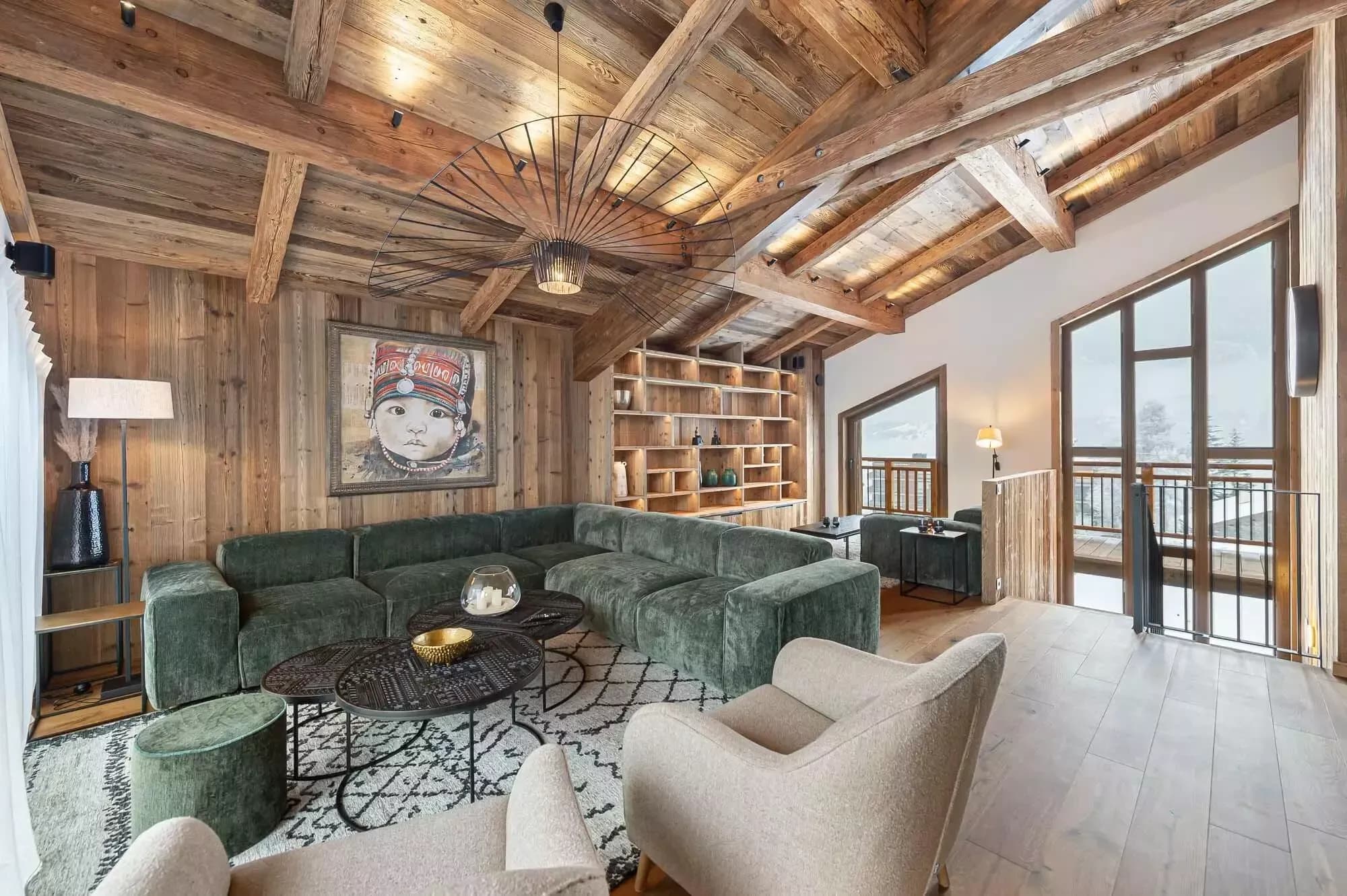 Top-floor lounge with timber beams, sectional seating and balcony access