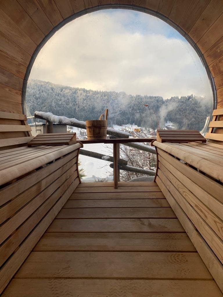Barrel sauna interior overlooking the snowy Morzine valley