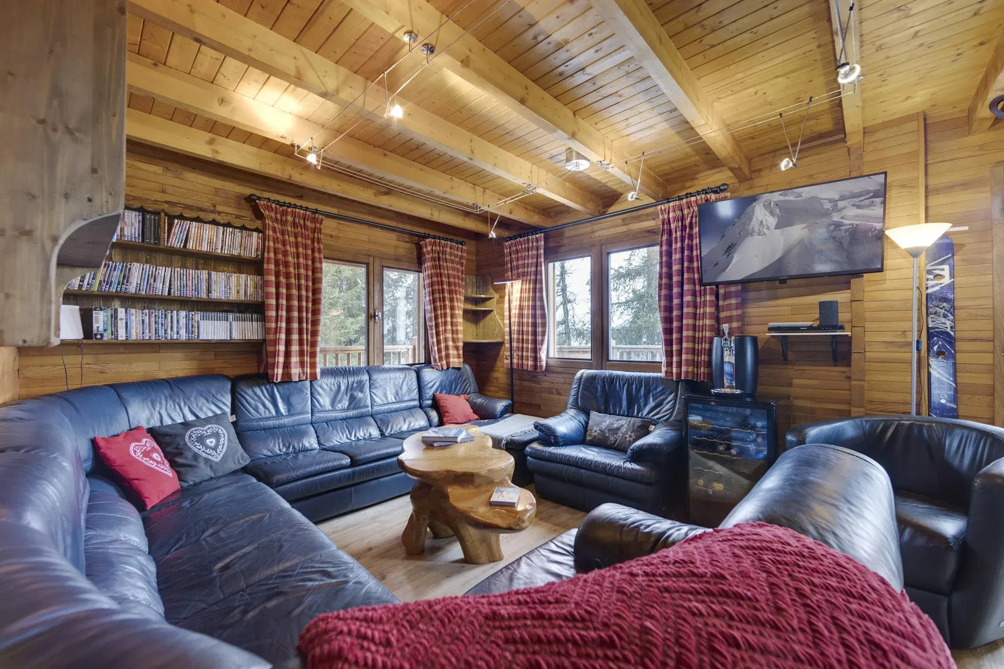 Lounge with leather corner sofa, armchairs, wall-mounted TV and bookshelves