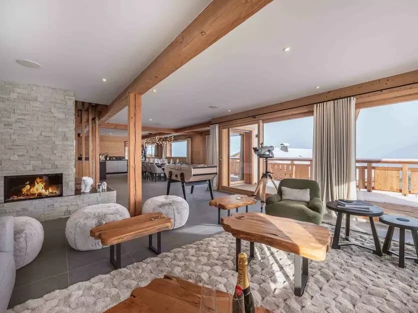 Living room beside the wood fireplace with balcony and mountain views