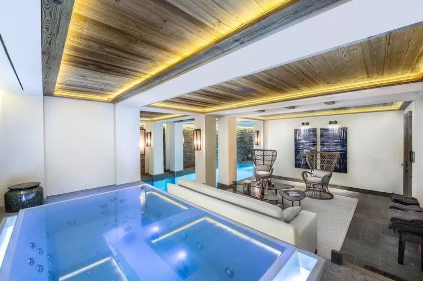 Indoor swimming pool beside a stone-walled lounge