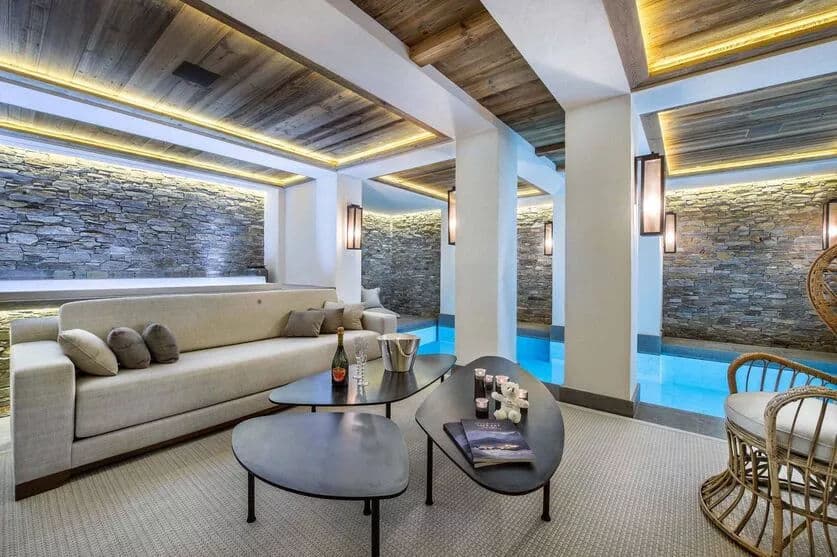 Poolside relaxation lounge with armchairs and stone walls