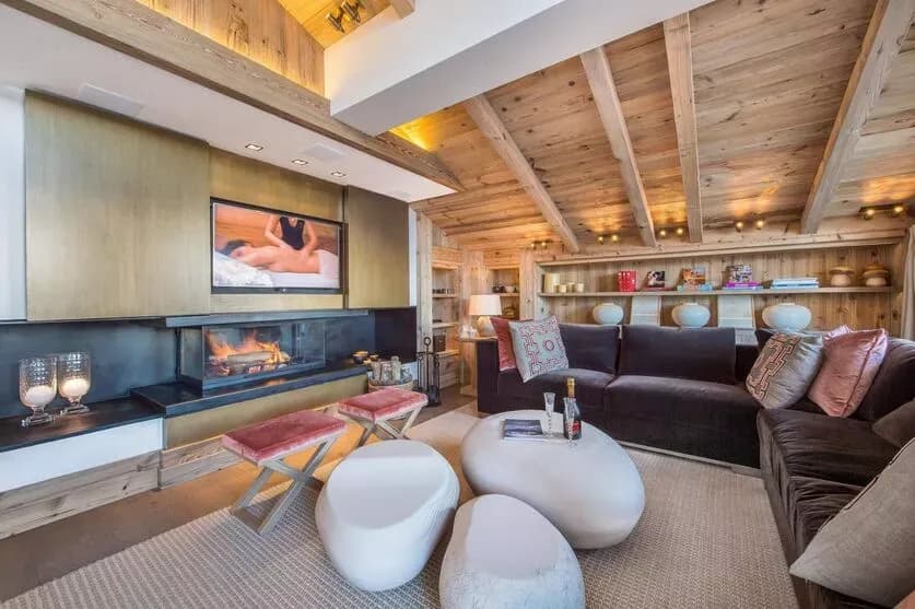 Living room with lounge seating, televisions and a glass fireplace