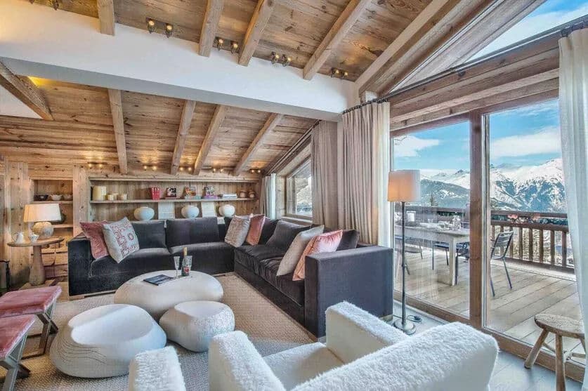 Living room with a glass fireplace and balcony doors overlooking the mountains