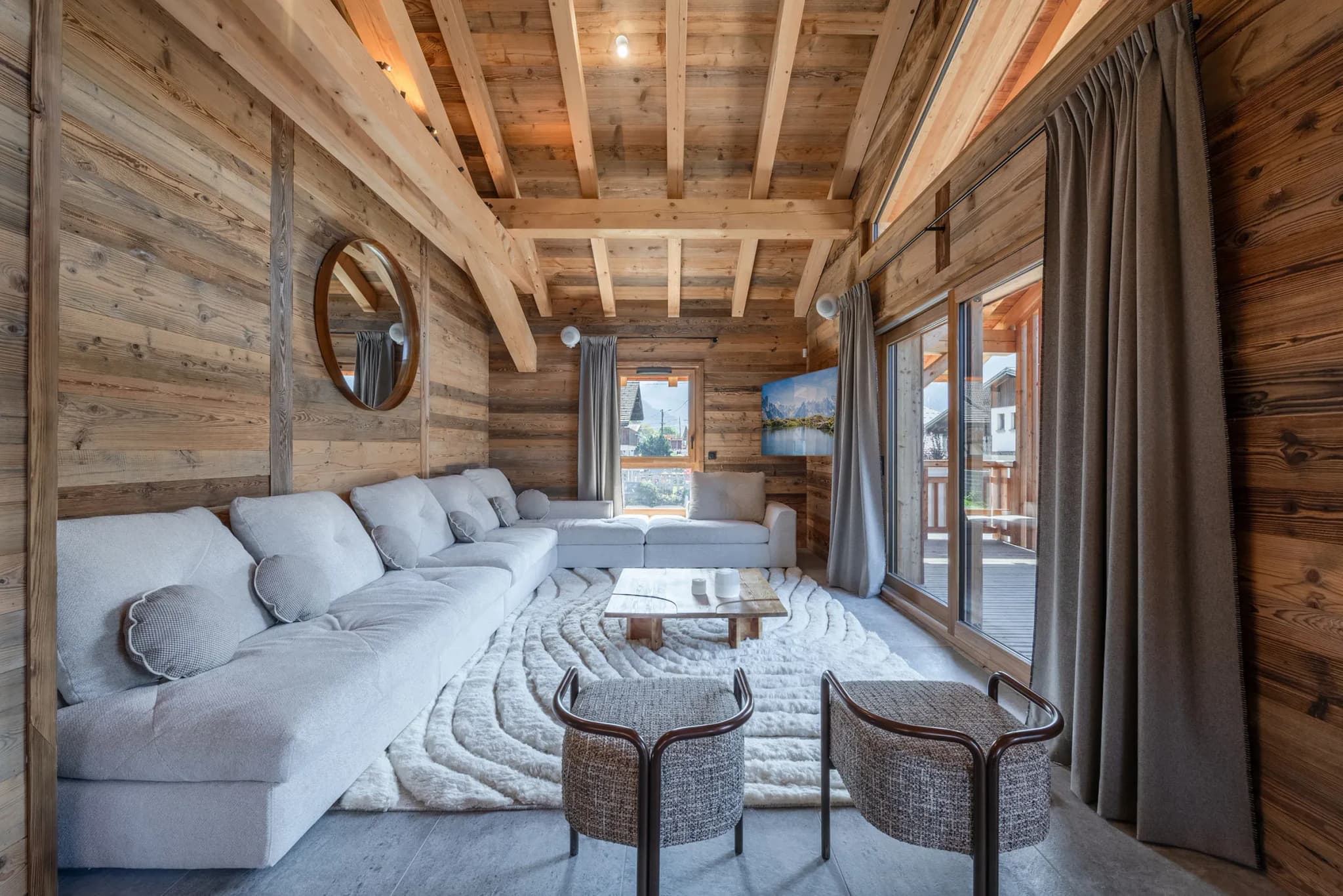 Living room with large L-shaped sofa, shaggy rug and sliding doors to balcony
