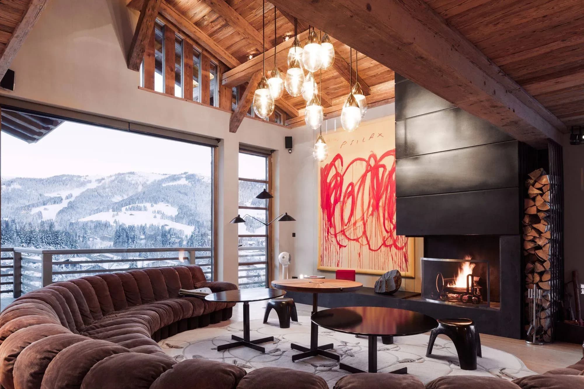 Living room with curved sectional seating, fireplace, and snow-covered valley views