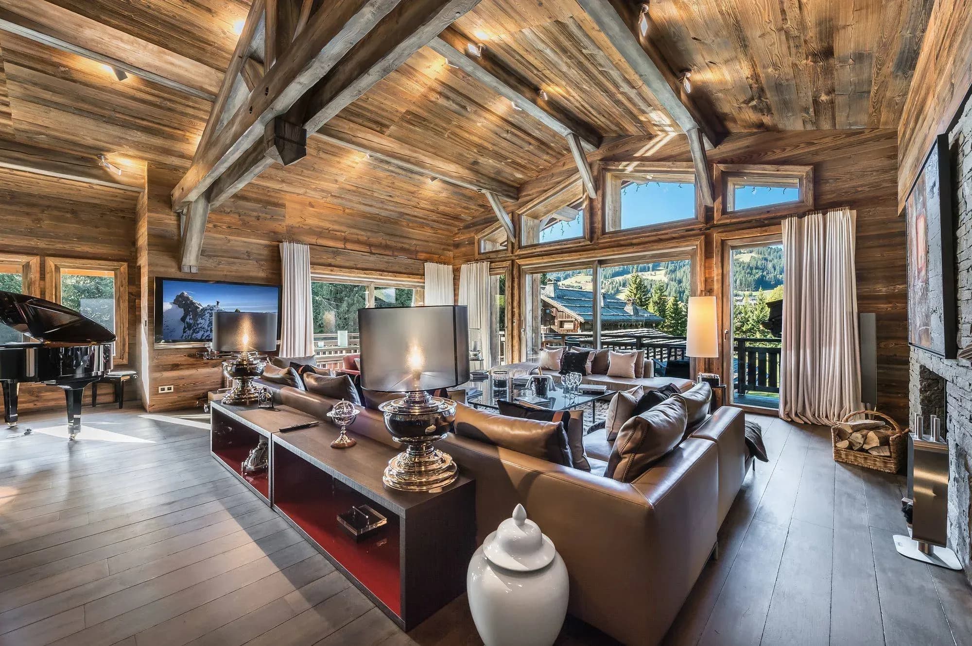 Living room with leather sofas, grand piano and floor-to-ceiling windows