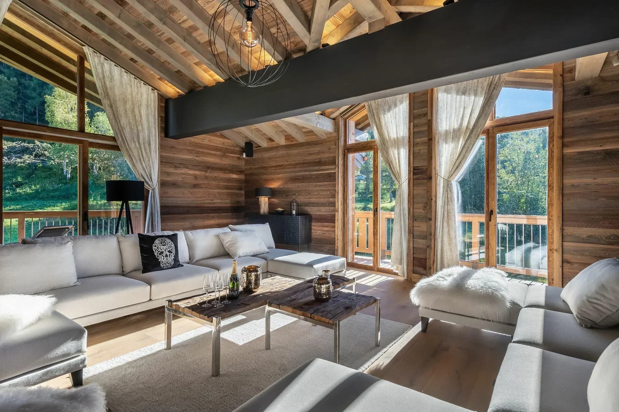 Living room with L-shaped sofa, reclaimed-wood coffee tables and balcony doors