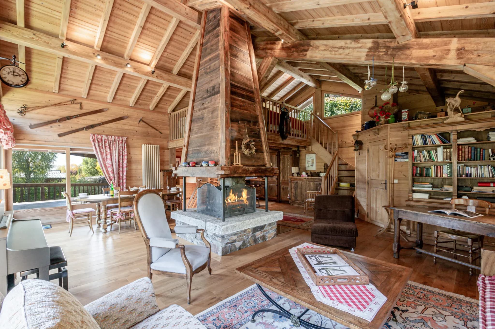 Living area with central stone-hearth fireplace, armchairs and wooden coffee table