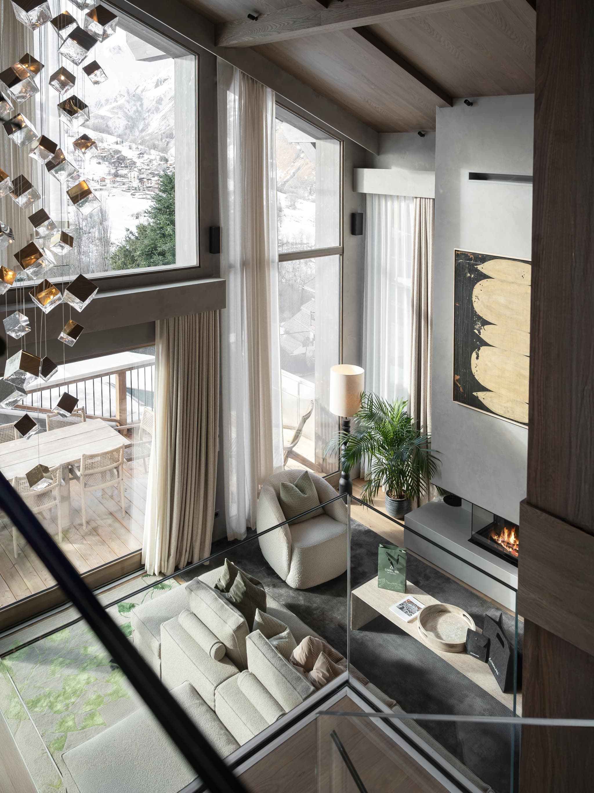 Multi-level living area with fireplace, floor-to-ceiling windows, and mountain views