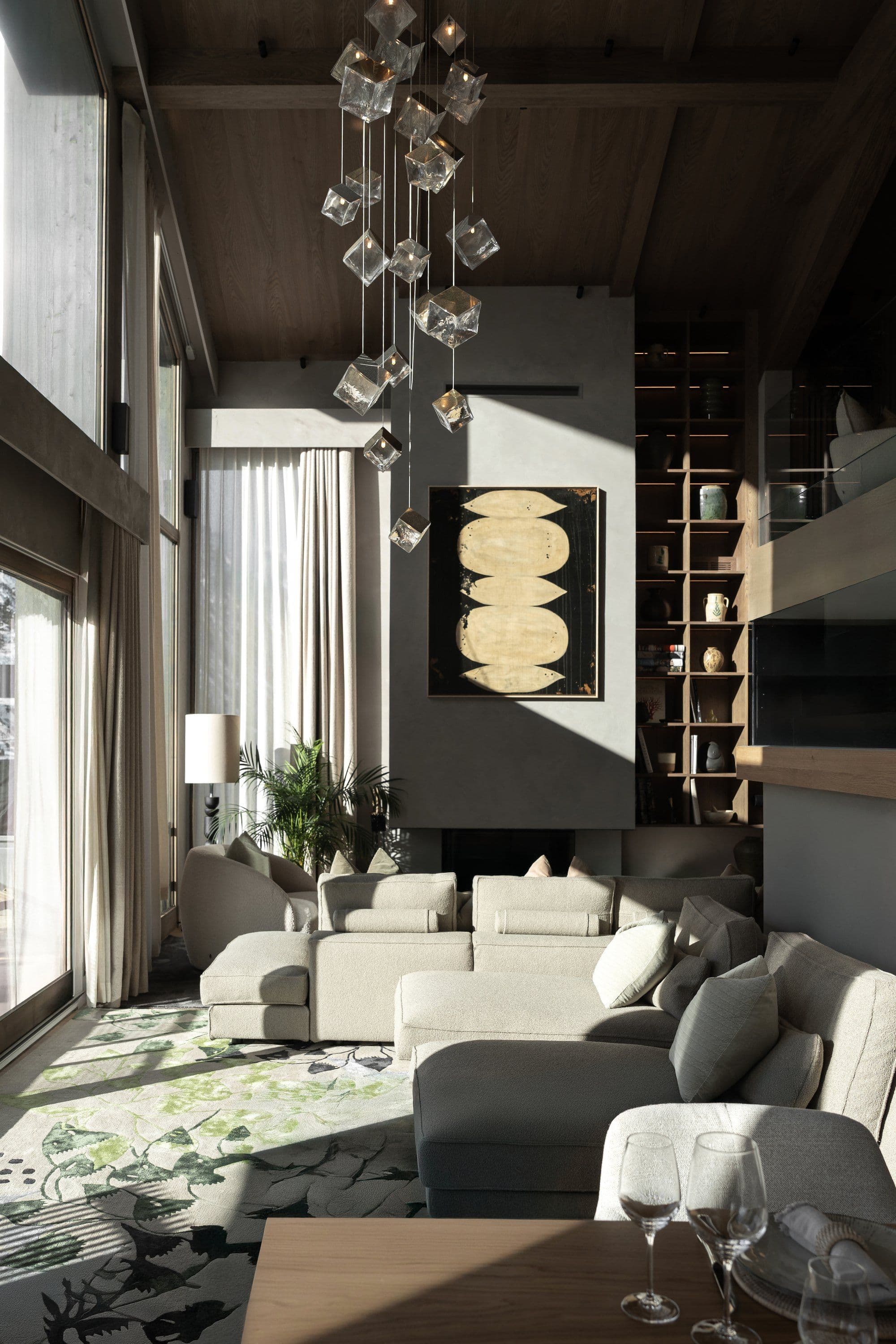 Living room with cascading crystal pendant light and floor-to-ceiling shelving