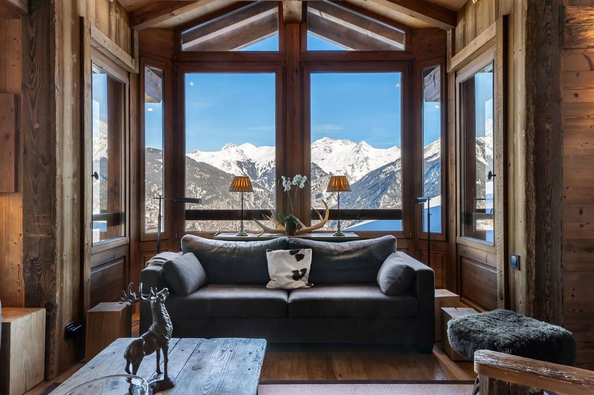 Timber-lined living room with panoramic snowy mountain views