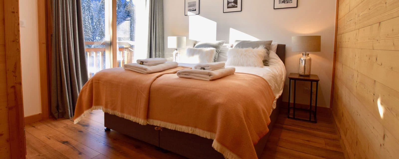 King/twin bedroom with a balcony and timber feature wall